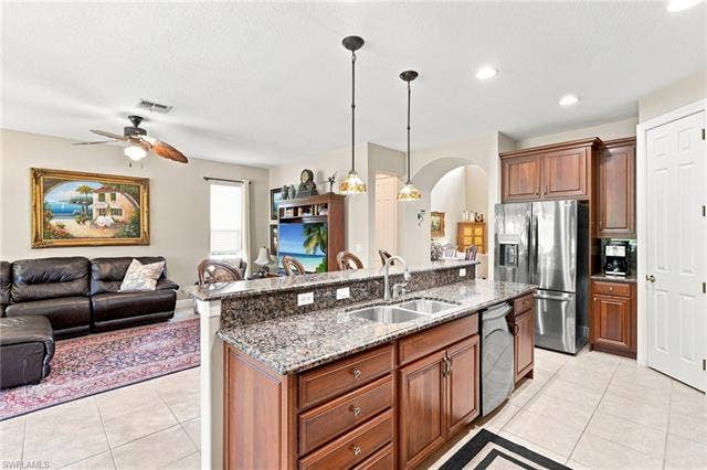 19600 Maddelena Cir, Estero, FL 33967 Kitchen island with granite countertops, dual basin stainless steel sink, and pendant lighting