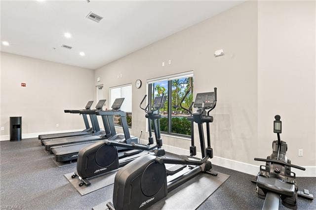19600 Maddelena Cir, Estero, FL 33967 Fitness area featuring multiple exercise machines, recessed ceiling lighting, and large windows