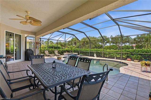 19600 Maddelena Cir, Estero, FL 33967 Screened patio with a built-in pool, ceiling fan, and tiled flooring
