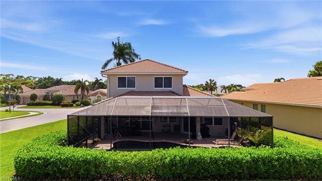 19600 Maddelena Cir, Estero, FL 33967 Two-story exterior with a tile roof, screened enclosure, and a swimming pool