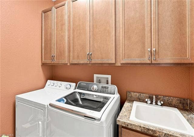 19600 Maddelena Cir, Estero, FL 33967 Upper cabinetry with panel doors, laminate countertop with integrated sink, and chrome faucet