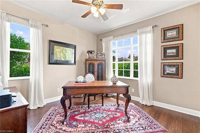 19600 Maddelena Cir, Estero, FL 33967 Hardwood flooring, painted walls, ceiling fan, and large windows