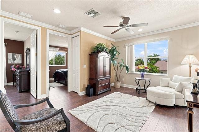 19600 Maddelena Cir, Estero, FL 33967 Wood-finish flooring throughout, tray ceiling with recessed lighting, and a ceiling fan