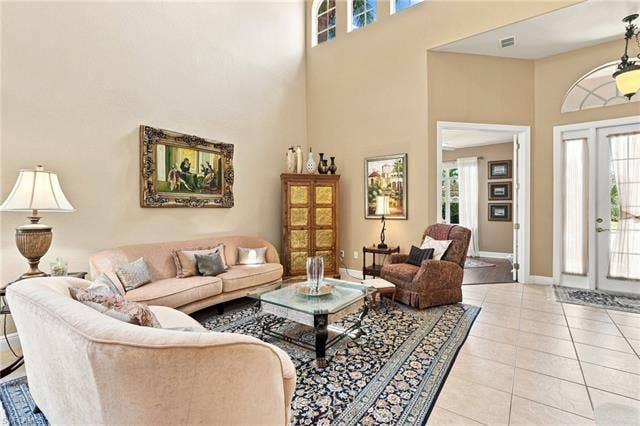19600 Maddelena Cir, Estero, FL 33967 Vaulted ceilings, transom window, and French doors complement the tiled flooring