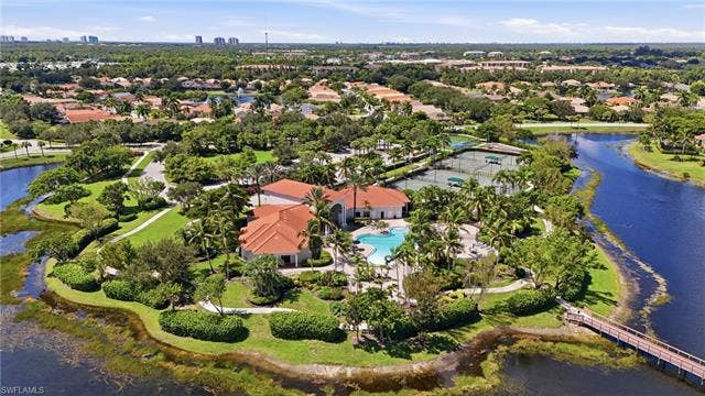 19600 Maddelena Cir, Estero, FL 33967 Community grounds featuring a swimming pool, tennis courts, and established landscaping