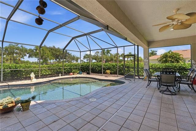 19600 Maddelena Cir, Estero, FL 33967 Screened lanai with an in-ground swimming pool, tiled patio, and a ceiling fan