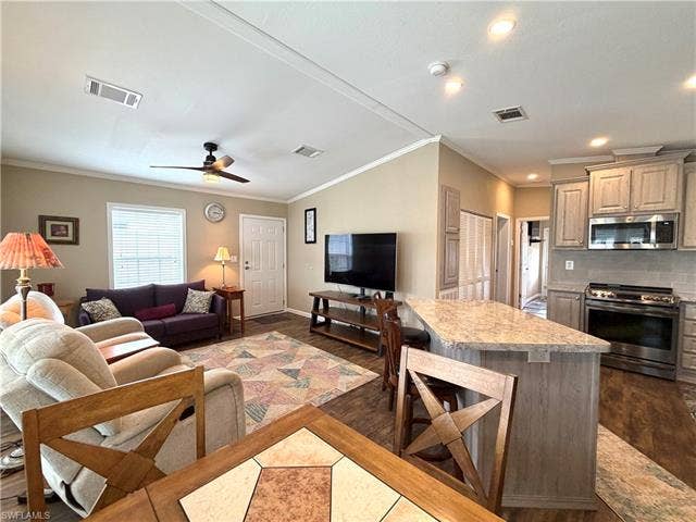 4710 W Lafayette Ln, Estero, FL 33928 Vaulted ceiling, ceiling fan, wood-finish flooring, kitchen island with seating, stainless steel appliances