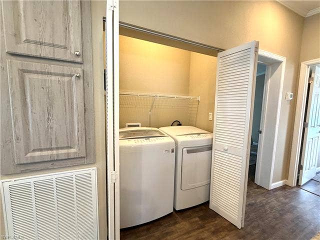 4710 W Lafayette Ln, Estero, FL 33928 Laundry closet with bi-fold louvered doors, wire shelving, and wood-finish flooring