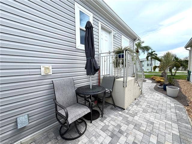 4710 W Lafayette Ln, Estero, FL 33928 Durable exterior siding, paved patio, and metal railing