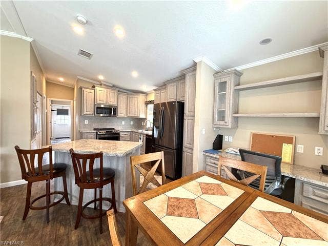 4710 W Lafayette Ln, Estero, FL 33928 Kitchen with light-toned cabinetry, granite-finish countertops, and built-in stainless steel appliances