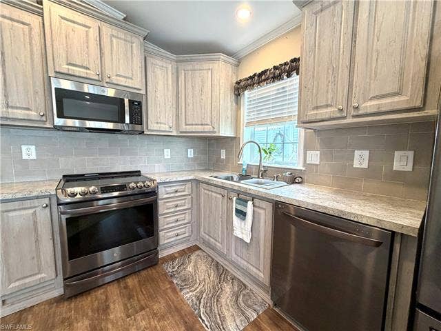 4710 W Lafayette Ln, Estero, FL 33928 Kitchen featuring stainless steel appliances, wood-finish cabinetry, light-colored countertops, and a subway tile backsplash