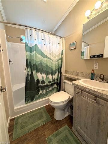 4710 W Lafayette Ln, Estero, FL 33928 Bathroom featuring a shower-tub combination, wood-finish flooring, a vanity with an integrated sink, and a mirrored medicine cabinet