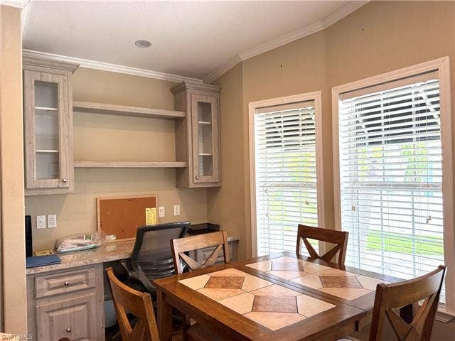 4710 W Lafayette Ln, Estero, FL 33928 Built-in desk area featuring wood-finish cabinetry with glass inserts, open shelving, and a light-colored countertop