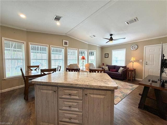 4710 W Lafayette Ln, Estero, FL 33928 Kitchen island with a light-toned countertop and paneled cabinetry