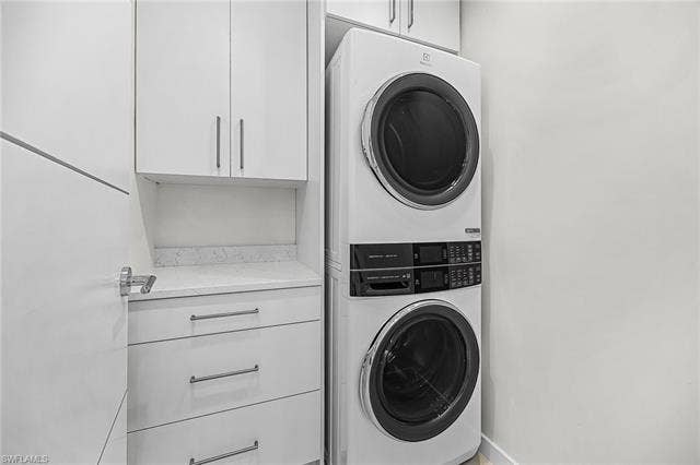 455 Palermo Cir, Fort Myers Beach, FL 33931 Laundry room with cabinet space and stacked washer and clothes dryer - Virtually Edited Image