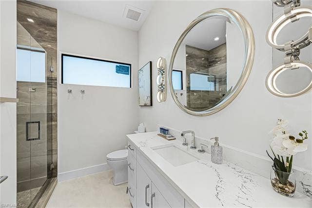 455 Palermo Cir, Fort Myers Beach, FL 33931 Full bath featuring vanity, a shower stall, and light tile patterned floors - Virtually Edited Image
