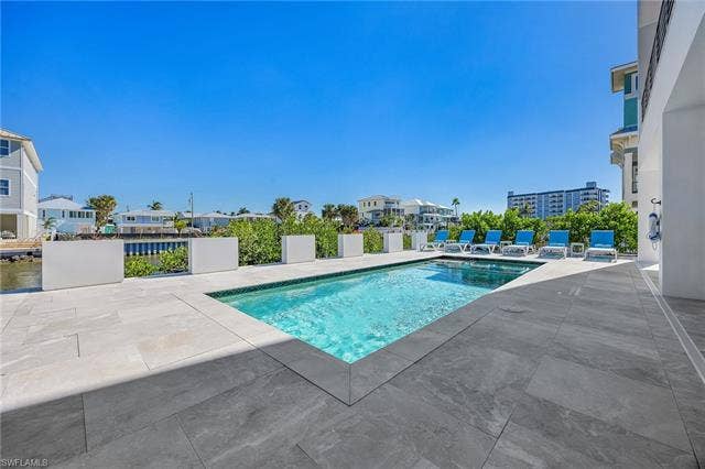 455 Palermo Cir, Fort Myers Beach, FL 33931 Outdoor pool with a patio area and a residential view - Virtually Edited Image