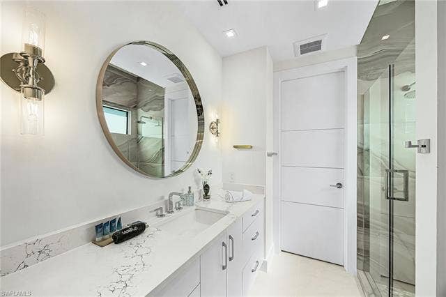455 Palermo Cir, Fort Myers Beach, FL 33931 Bathroom featuring vanity and a marble finish shower - Virtually Edited Image