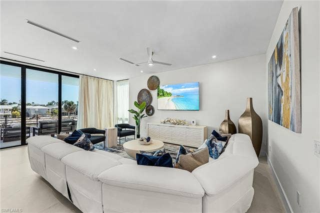 455 Palermo Cir, Fort Myers Beach, FL 33931 Living room featuring floor to ceiling windows, recessed lighting, and a ceiling fan - Virtually Edited Image