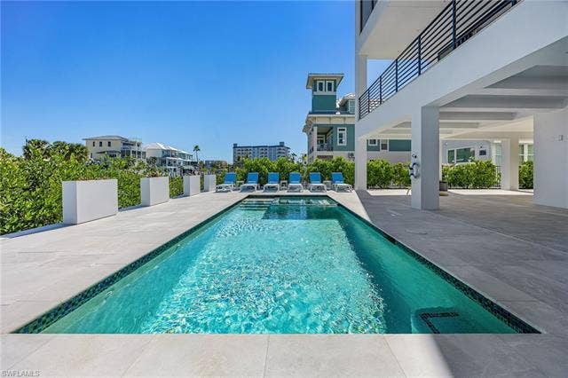 455 Palermo Cir, Fort Myers Beach, FL 33931 View of swimming pool with a patio area and a balcony - Virtually Edited Image