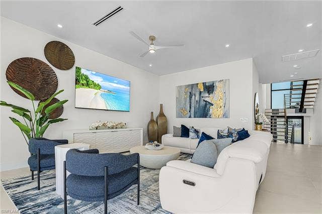 455 Palermo Cir, Fort Myers Beach, FL 33931 Living room featuring ceiling fan, floor to ceiling windows, and recessed lighting - Virtually Edited Image