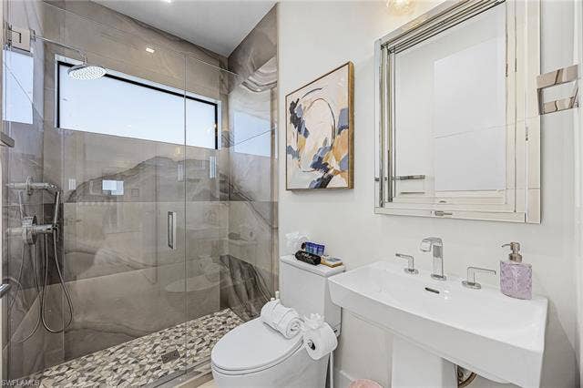 455 Palermo Cir, Fort Myers Beach, FL 33931 Full bath featuring a stall shower and toilet - Virtually Edited Image
