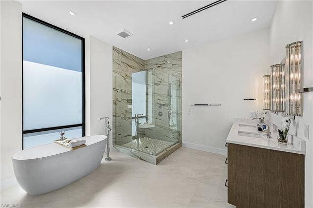 455 Palermo Cir, Fort Myers Beach, FL 33931 Full bath featuring double vanity, a freestanding bath, and a marble finish shower - Virtually Edited Image