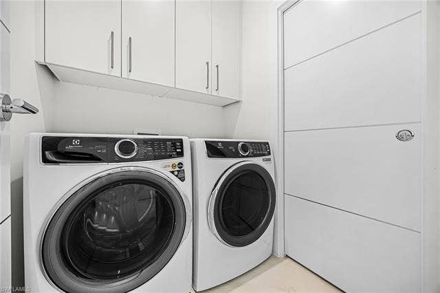 455 Palermo Cir, Fort Myers Beach, FL 33931 Laundry room with washer and clothes dryer and cabinet space - Virtually Edited Image