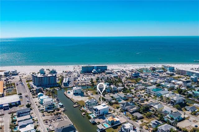 455 Palermo Cir, Fort Myers Beach, FL 33931 Aerial overview of property's location featuring a large body of water and nearby urban area - Virtually Edited Image