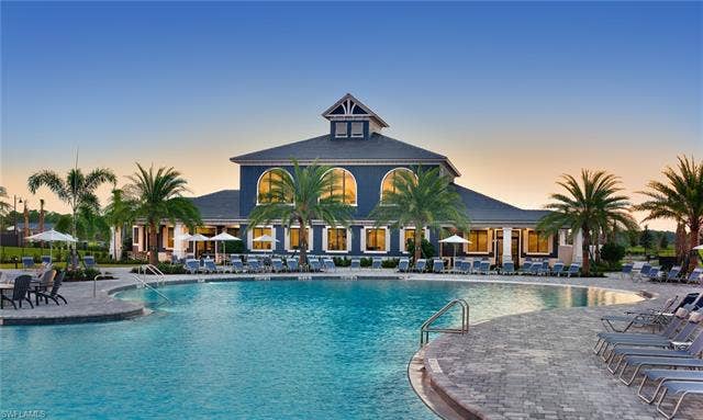 19712 The Place Blvd, Estero, FL 33928 Expansive Community clubhouse and pool area featuring a large central pool, surrounding lounge seating, and paved decking