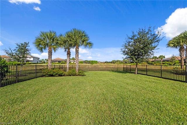 19712 The Place Blvd, Estero, FL 33928 Expansive green lawn with mature palm trees and established landscaping