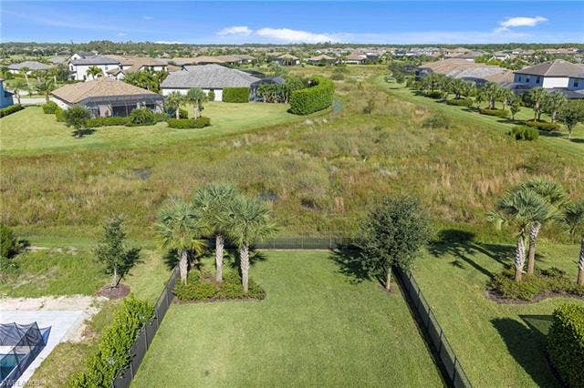 19712 The Place Blvd, Estero, FL 33928 Fenced backyard with manicured lawn and mature landscaping. Preserve view.