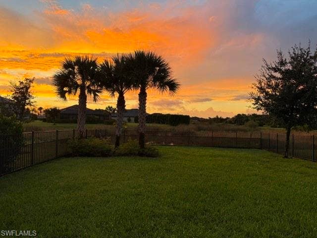 19712 The Place Blvd, Estero, FL 33928 Expansive green lawn, perimeter fencing, multiple mature palm trees.