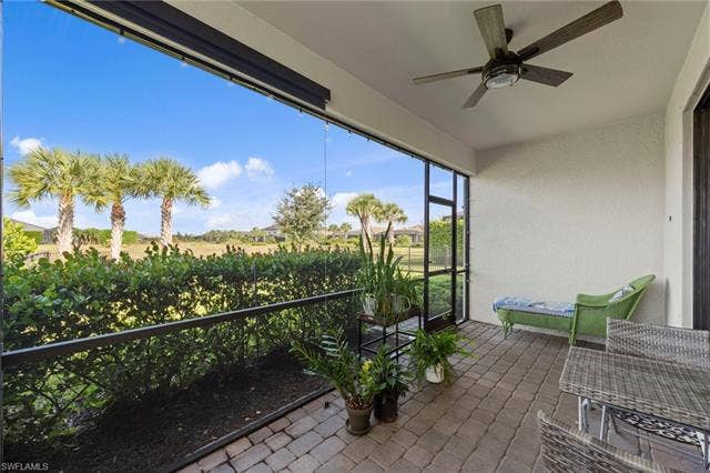 19712 The Place Blvd, Estero, FL 33928 Screened lanai featuring a ceiling fan, textured wall finish, motorized privacy screens and paver flooring