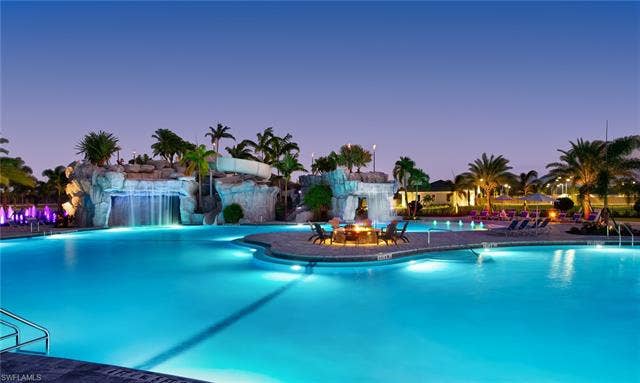 19712 The Place Blvd, Estero, FL 33928 Expansive Community swimming pool with integrated lighting, rock formations, and a water slide.