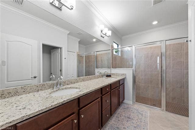 19712 The Place Blvd, Estero, FL 33928 Dual vanity with stone countertop, wood-finish cabinetry, extra-large shower and undermount sinks