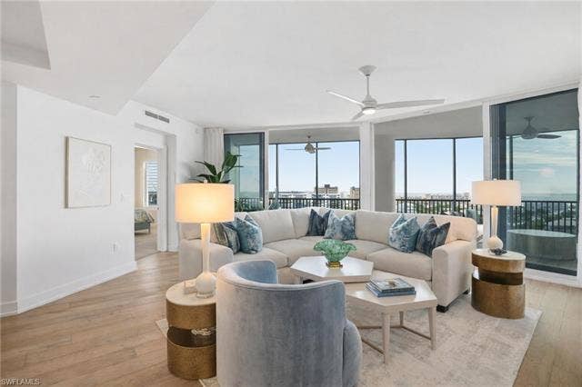 4142 Bay Beach Ln, #904, Fort Myers Beach, FL 33931 Living area featuring expansive windows, healthy amount of natural light, and light wood finished floors - Virtually Edited Image