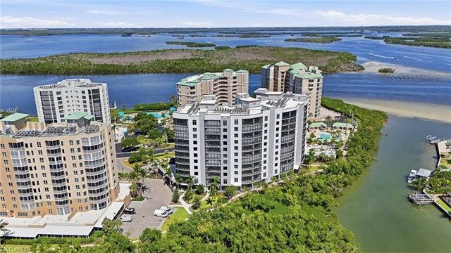 4142 Bay Beach Ln, #904, Fort Myers Beach, FL 33931 Bird's eye view of apartment complex and a large body of water - Virtually Edited Image