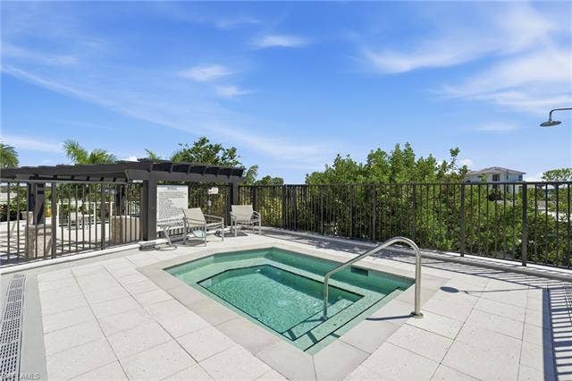 4142 Bay Beach Ln, #904, Fort Myers Beach, FL 33931 View of pool with a community hot tub and a patio area - Virtually Edited Image