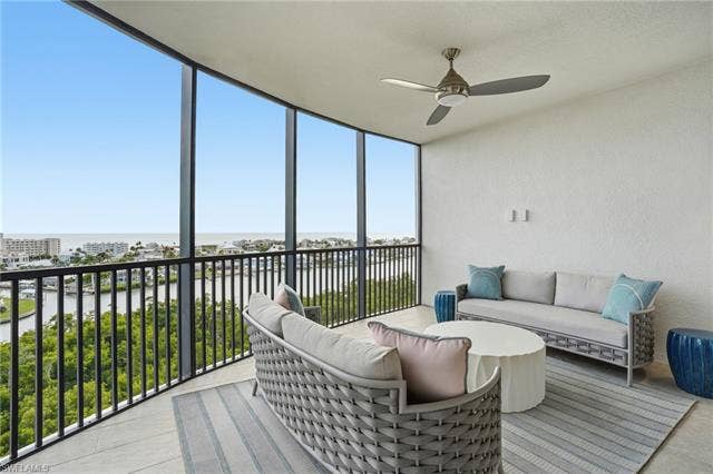 4142 Bay Beach Ln, #904, Fort Myers Beach, FL 33931 Sunroom with a water view, outdoor lounge area, and a ceiling fan - Virtually Edited Image