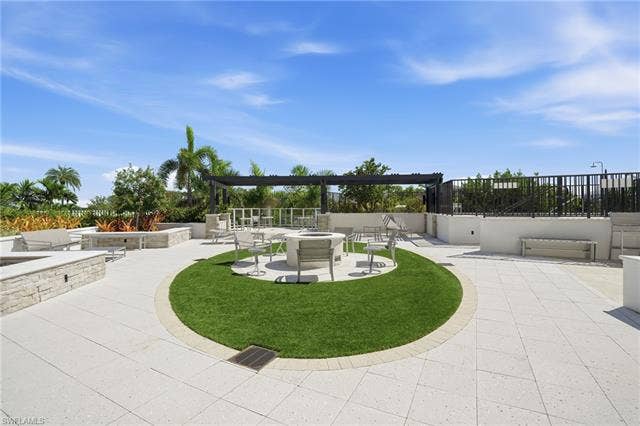 4142 Bay Beach Ln, #904, Fort Myers Beach, FL 33931 View of community featuring a fire pit and a patio area - Virtually Edited Image