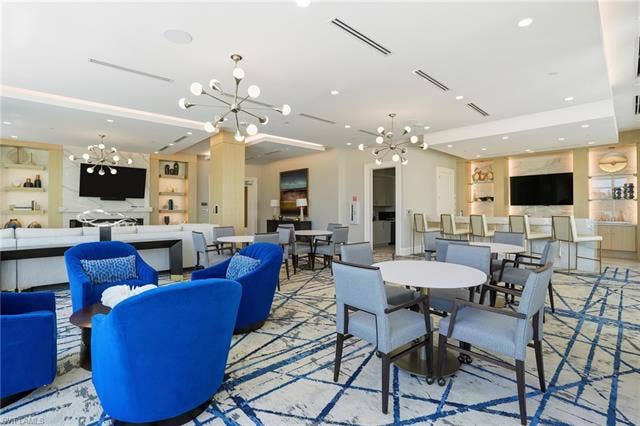 4142 Bay Beach Ln, #904, Fort Myers Beach, FL 33931 Dining area featuring a chandelier, recessed lighting, and built in shelves - Virtually Edited Image
