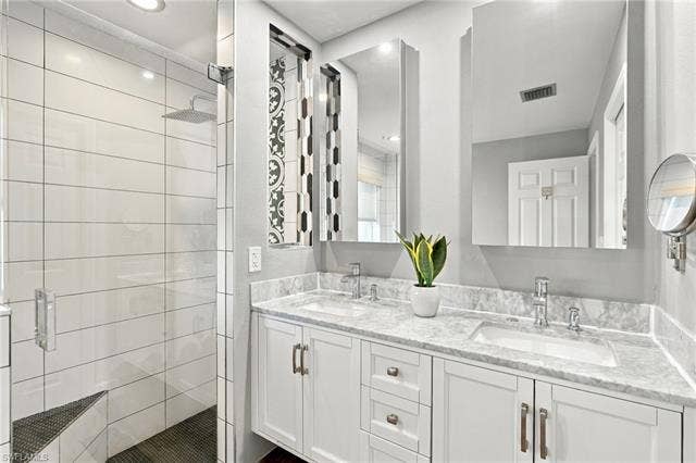 20052 Serene Meadow Ln, Estero, FL 33928 Dual vanity with undermount sinks, stone countertops, and chrome fixtures