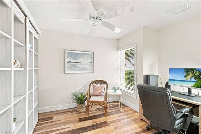 20052 Serene Meadow Ln, Estero, FL 33928 Wood-finish flooring, built-in shelving, white ceiling fan, single window with blinds, and light-toned wall paint