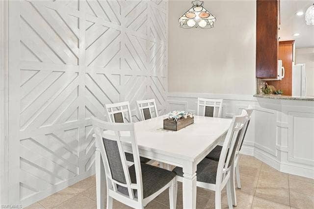 20052 Serene Meadow Ln, Estero, FL 33928 Decorative geometric wall paneling, tile flooring, wainscoting, and a stained glass pendant light fixture