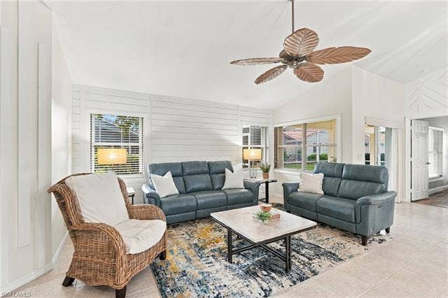 20052 Serene Meadow Ln, Estero, FL 33928 Vaulted ceilings with a decorative ceiling fan, horizontal plank wall accents, multiple windows with blinds, and tile flooring