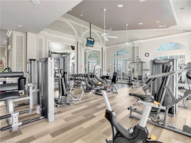 20052 Serene Meadow Ln, Estero, FL 33928 Fitness center with wood-finish flooring, vaulted ceilings, arched windows, and recessed lighting