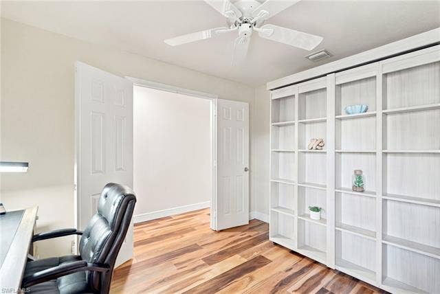 20052 Serene Meadow Ln, Estero, FL 33928 Wood-finish flooring, built-in shelving, ceiling fan, and white paneled doors