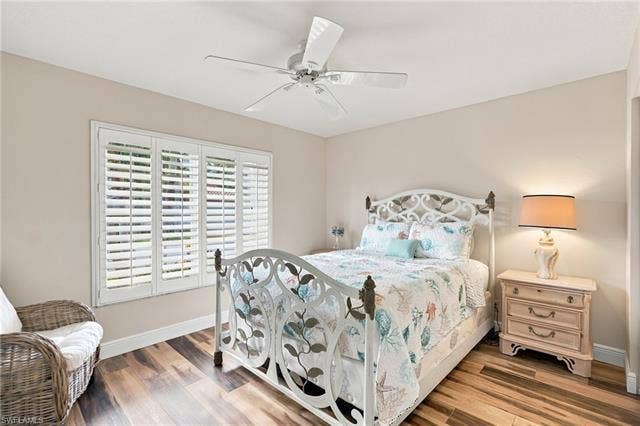 20052 Serene Meadow Ln, Estero, FL 33928 Wood-finish flooring, ceiling fan, white window shutters, and neutral wall tones