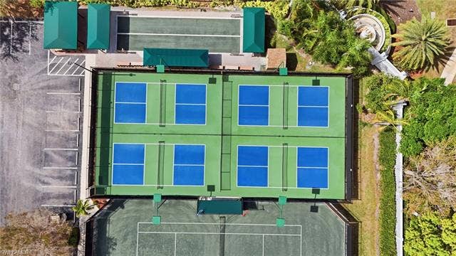 20052 Serene Meadow Ln, Estero, FL 33928 Four pickleball courts, two bocce ball courts, and a tennis court are present, complemented by a parking area and lush landscaping